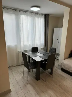 a dining room table and chairs in a room at Refurbished apartment in a quiet area in Sofia