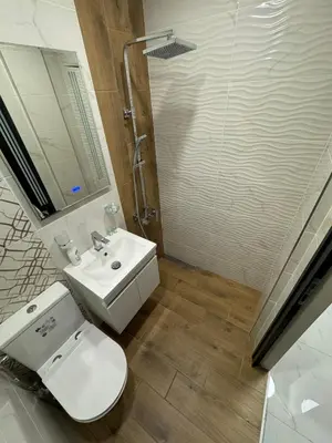 a bathroom with a toilet and a sink and a shower at Refurbished apartment in a quiet area in Sofia
