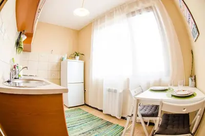 a kitchen with a sink and a table with chairs at 19 Cozy Central Apartment with Balcony in Sofia