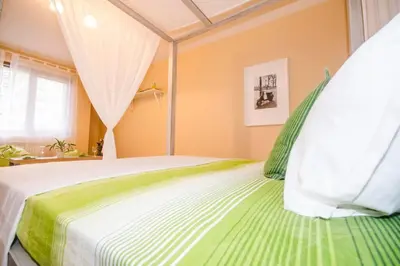 a green and white bed in a room with a window at 19 Cozy Central Apartment with Balcony in Sofia