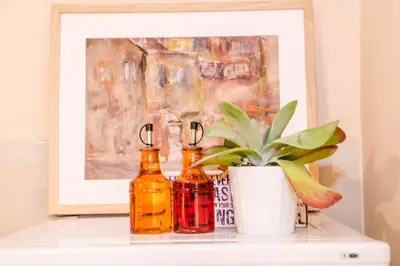 a painting and two bottles on a shelf with a plant at 23 Central 1 Bedroom Apartment with Balcony in Sofia