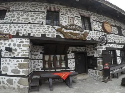 a stone building with a bench in front of it at Monastery Apartment C39 in Bansko