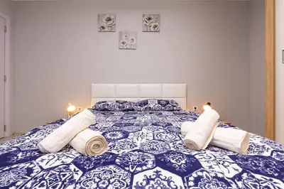 a blue and white bed with rolled towels on it at Central apt 'SELIN' Walking distance to center in Plovdiv