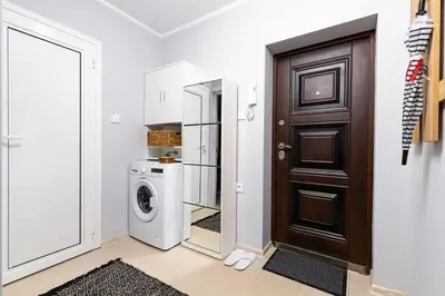 a bathroom with a washer and dryer next to a door at Central apt 'SELIN' Walking distance to center in Plovdiv