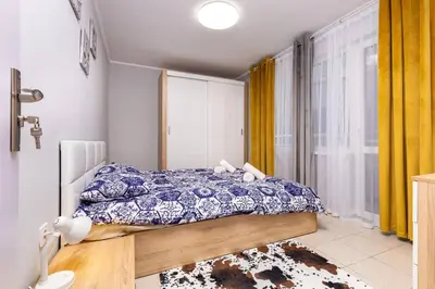 a bedroom with a bed and a window with yellow curtains at Central apt 'SELIN' Walking distance to center in Plovdiv