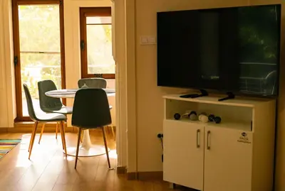 a living room with a television and a table with chairs at 2-Bedroom Flat - Sunny Balcony in Plovdiv