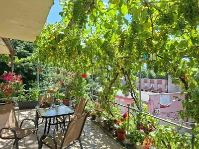 a table and chairs on a balcony with flowers at 2-Bedroom Flat - Sunny Balcony in Plovdiv