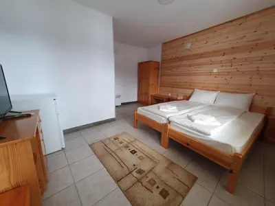 a bedroom with a bed with a wooden wall at ЕДЕЛВАЙС Сърница in Sarnitsa