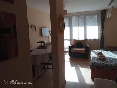 a room with a bed and a living room with a table at studio royal park bansko in Bansko