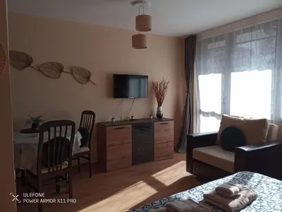 a living room with a tv and a couch and a table at studio royal park bansko in Bansko
