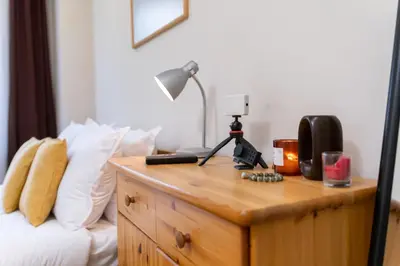 a desk with a lamp and a phone on top of a bed at Chic Urban Getaway in City Center by Flat Mаnager in Plovdiv