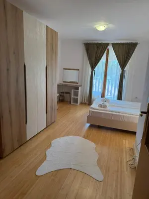 a bedroom with a bed and a white rug at Aparthotel Raikov Ski Lodge in Pamporovo