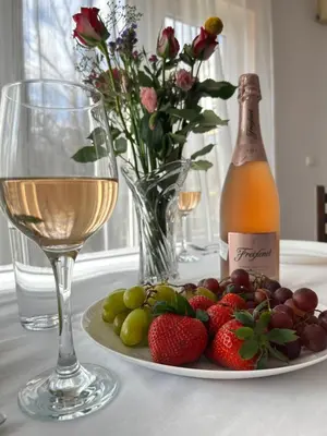 a plate of fruit with a bottle of wine and a glass at Casa Rea - Comfortable Stay with Free Parking in Sofia
