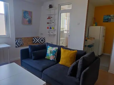 a living room with a blue couch and yellow pillows at Апартамент Pavlin in Plovdiv