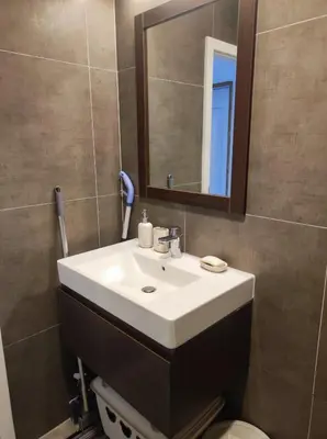 a bathroom with a white sink and a mirror at Апартамент Pavlin in Plovdiv