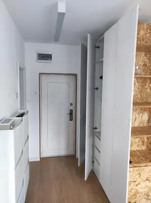 a white room with a door and a wooden floor at Апартамент Pavlin in Plovdiv