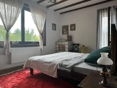 a bedroom with a bed and a large window at Guest House Opa in Smolyan