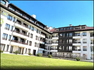 a large apartment building with a green lawn in front of it at Ski Lift Apartment in Bansko in Bansko