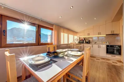 a kitchen with a table with chairs and a tableasteryasteryasteryasteryasteryastery at Apartment Yana- The Amazing View in Smolyan