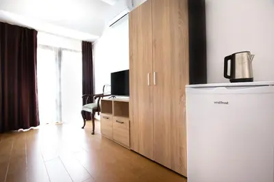 a living room with a refrigerator and a tv at Nova Guesthouse - Private En-Suite Rooms I Sofia Center I Self Check-In in Sofia