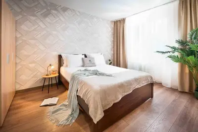 a bedroom with a bed and a potted plant at Spacious and relaxing in Sofia