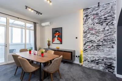 a dining room with a table and a tv at Urban Elegance Apartment in Sofia