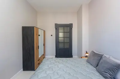 a bedroom with a bed and a black door at Urban Elegance Apartment in Sofia