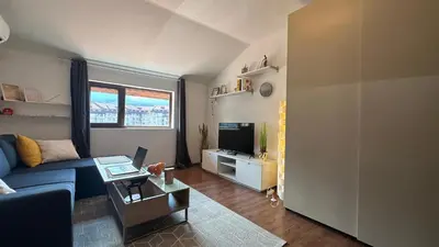 a living room with a blue couch and a tv at Ski Nomad Bansko in Bansko