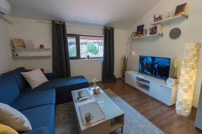 a living room with a blue couch and a tv at Ski Nomad Bansko in Bansko