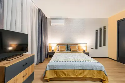 a bedroom with a bed and a flat screen tv at Best Guest 2 Apartments in Plovdiv