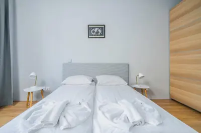 a bed with white sheets and white towels on it at Modern and Central 1BD Flat with Balcony by Flat Mаnager in Sofia