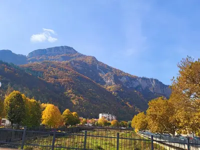 a mountain in the distance with a fence and trees at Luxury apartment in Teteven