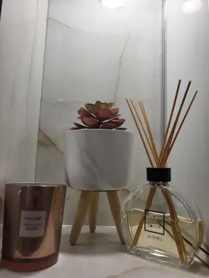 a table with a candle and a vase with a plant at Luxury apartment in Teteven