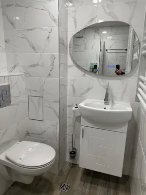 a white bathroom with a toilet and a sink at MonarX Suites in Bansko