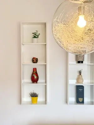 a white book shelf with vases and a chandelier at Main Street Sunshine 2 KING Bdr in Sofia