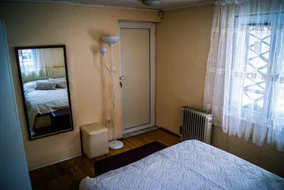 a bedroom with a bed and a mirror and a window at NIKI Apart in Sofia
