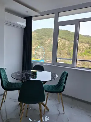 a table and chairs in a room with a window at Sandanski park view in Sandanski