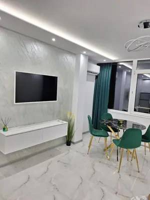 a living room with a tv and a table and chairs at Sandanski park view in Sandanski