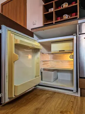 an empty refrigerator with its door open in a kitchen at Cedar Lodge 2 Bedroom Apartment by Flat Mаnager in Bansko