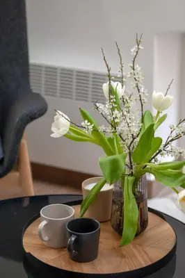 a table with a vase with white flowers and two cups at Ruby Red House in Sofia