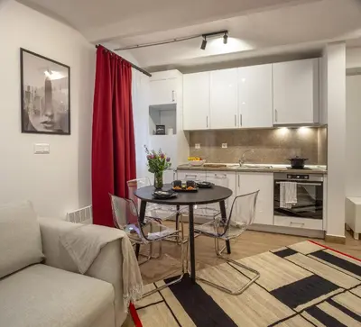 a living room with a table and a kitchen at Ruby Red House in Sofia