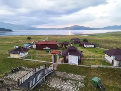 an aerial view of a farm with houses and water at Къщи за гости in Batak