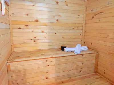 a wooden sauna with a bench in the corner at Stone house (Каменната къща) in Leshten