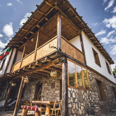 a large wooden house with a stone facade at Stone house (Каменната къща) in Leshten