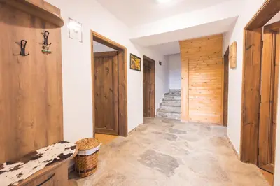 a hallway with wooden doors and stairs in a house at Stone house (Каменната къща) in Leshten