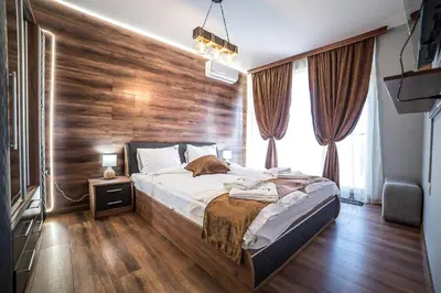 a bedroom with a large bed with a wooden wall at Apartment Tiana Lux 2 in Hisarya