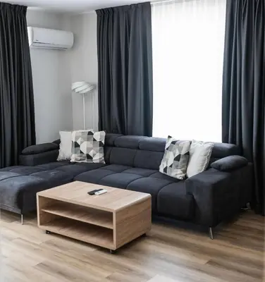 a living room with a blue couch and a coffee table at ТОП Апартаменти в Панорама Парк in Plovdiv