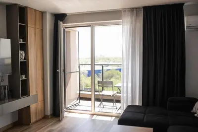 a living room with a couch and a large window at ТОП Апартаменти в Панорама Парк in Plovdiv