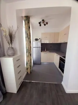 a small kitchen with a refrigerator and a table at Luxury Apartment two bedrooms Paul Sеzanne in Hisarya