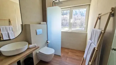 a bathroom with a sink and a toilet and a mirror at Waterside SPA Hotel in Ognyanovo